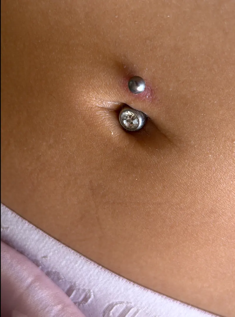 Close-up of a navel piercing with a gem-set bottom ball