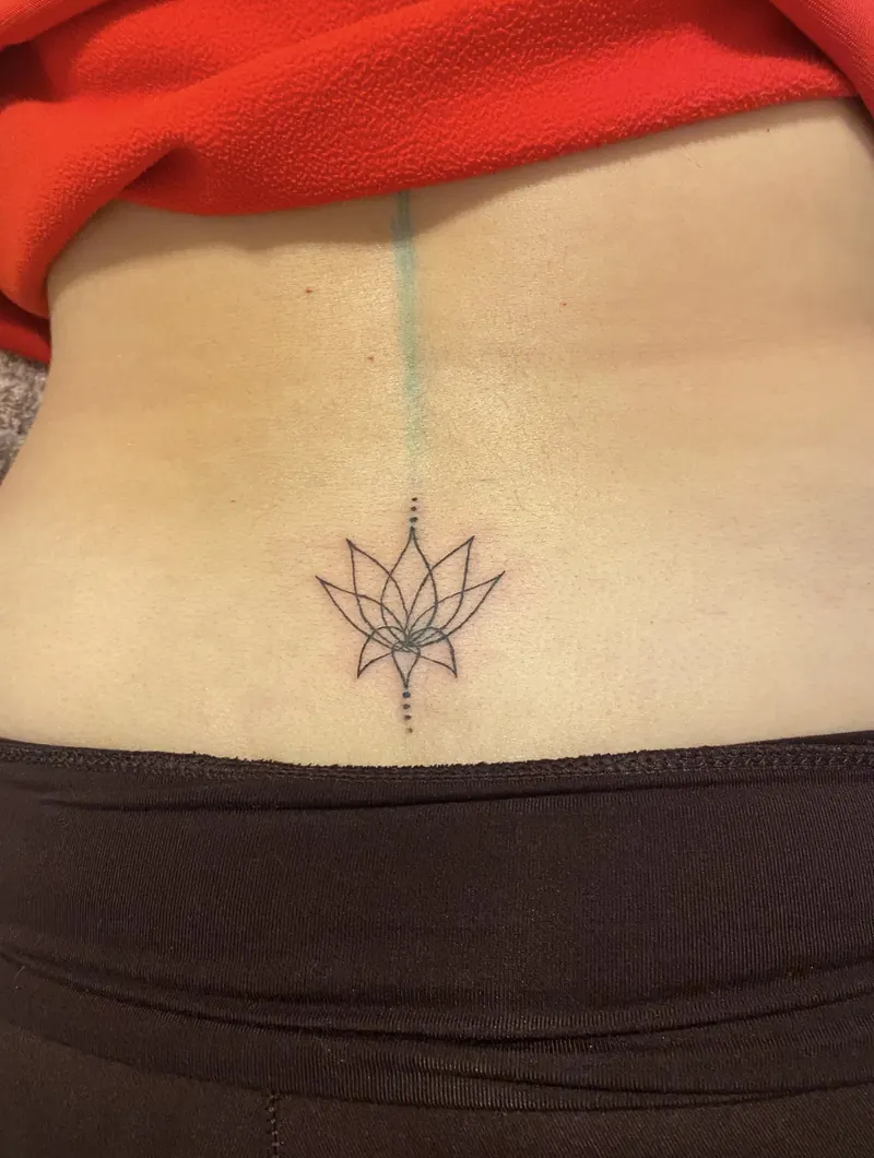 Fine line lotus tattoo with dotted accents below the navel